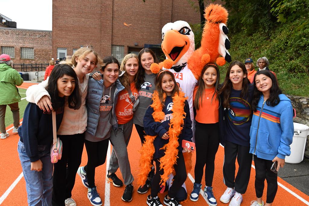 返校节期间，一群ECFS学生聚集在操场上与菲尔德斯顿鹰吉祥物合影留念.