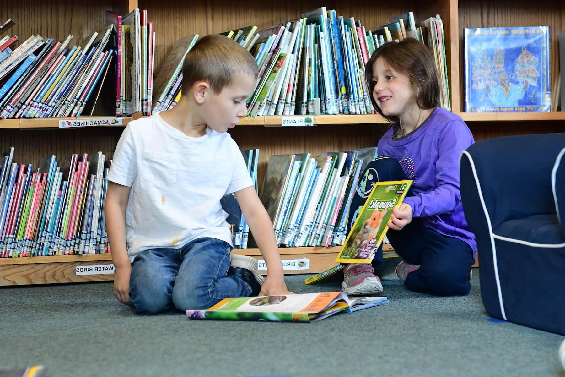 道德文化菲尔德斯顿学校低年级的学生在图书馆分享书籍