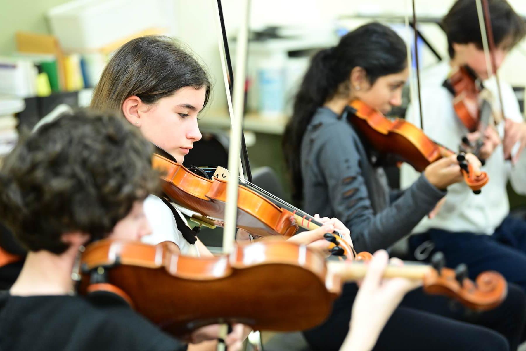 菲尔德斯顿学校学生在弦乐课上练习小提琴