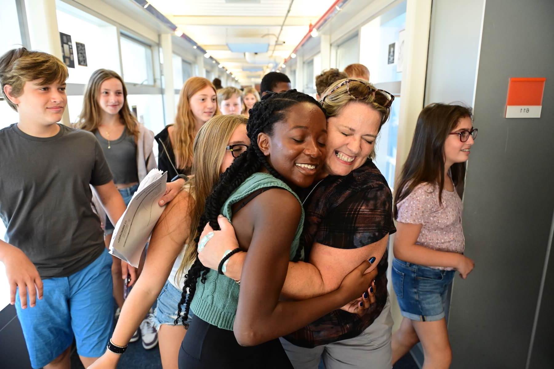 Ethical Culture Fieldston School Fieldston Middle student embraces teacher in a hug