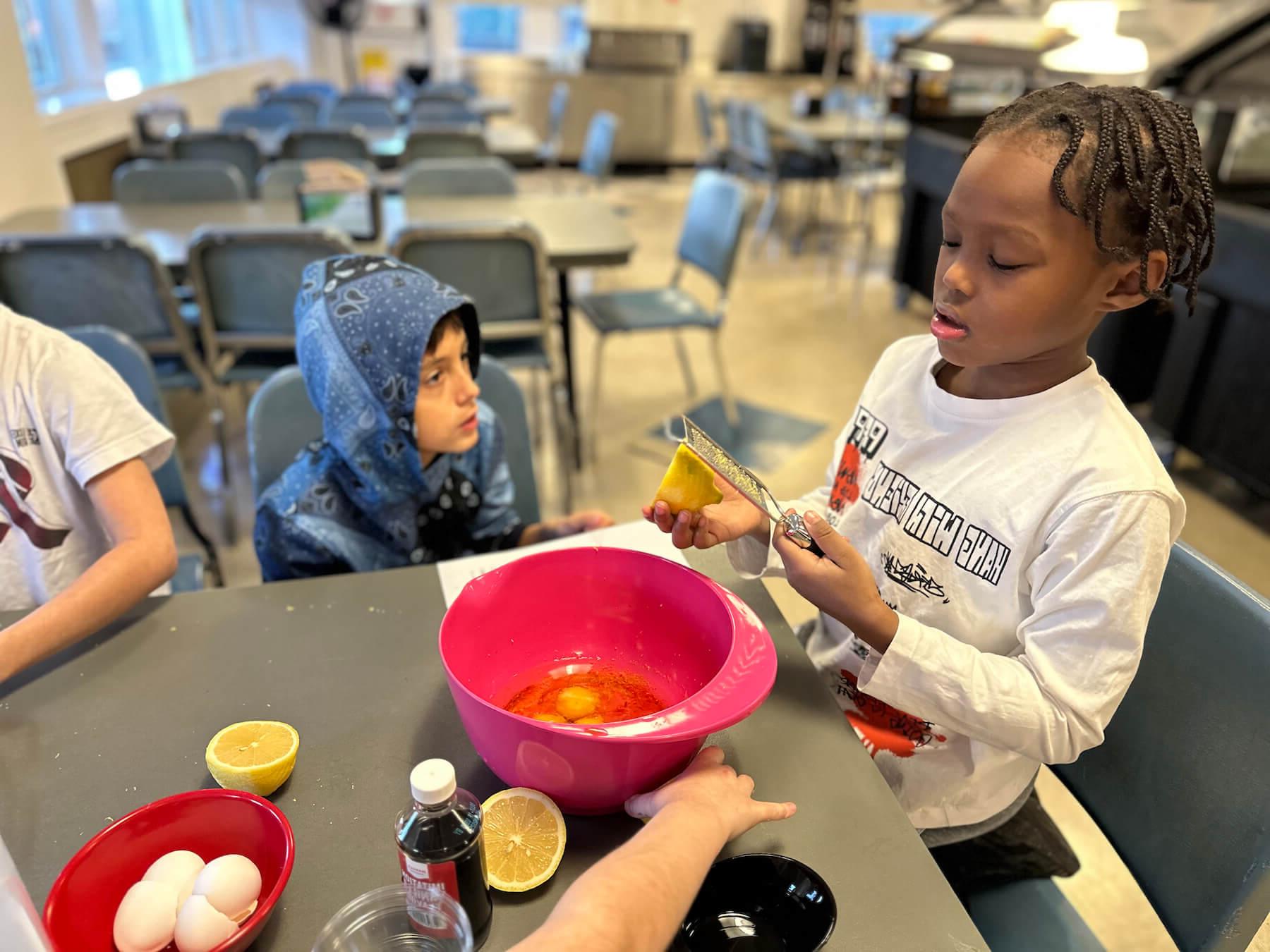 Ethical Culture Fieldston School students zesting a lemon in after school cooking class