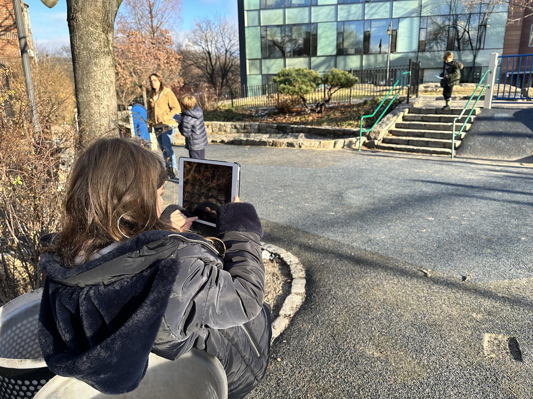 学生在菲尔德斯顿小学用iPad拍摄操场外的照片.