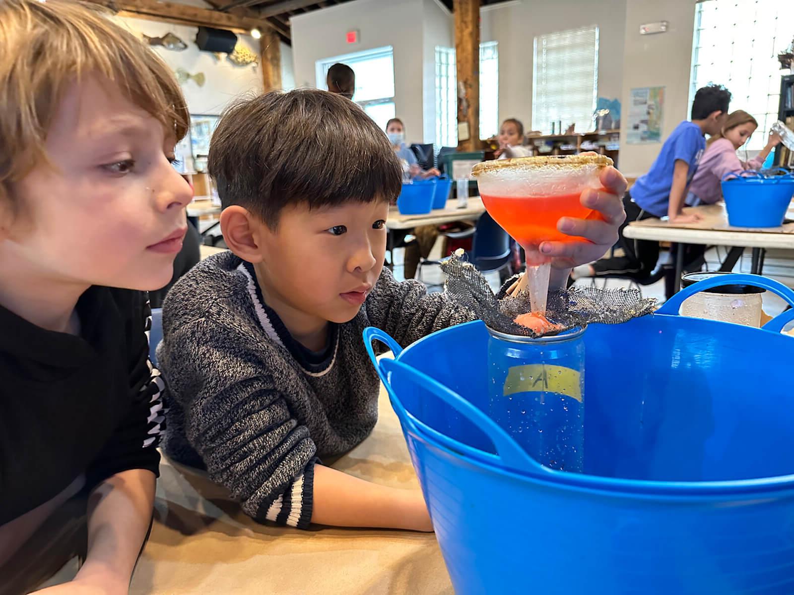 Fieldston Lower students clean water using a filter at the Beczak Center.