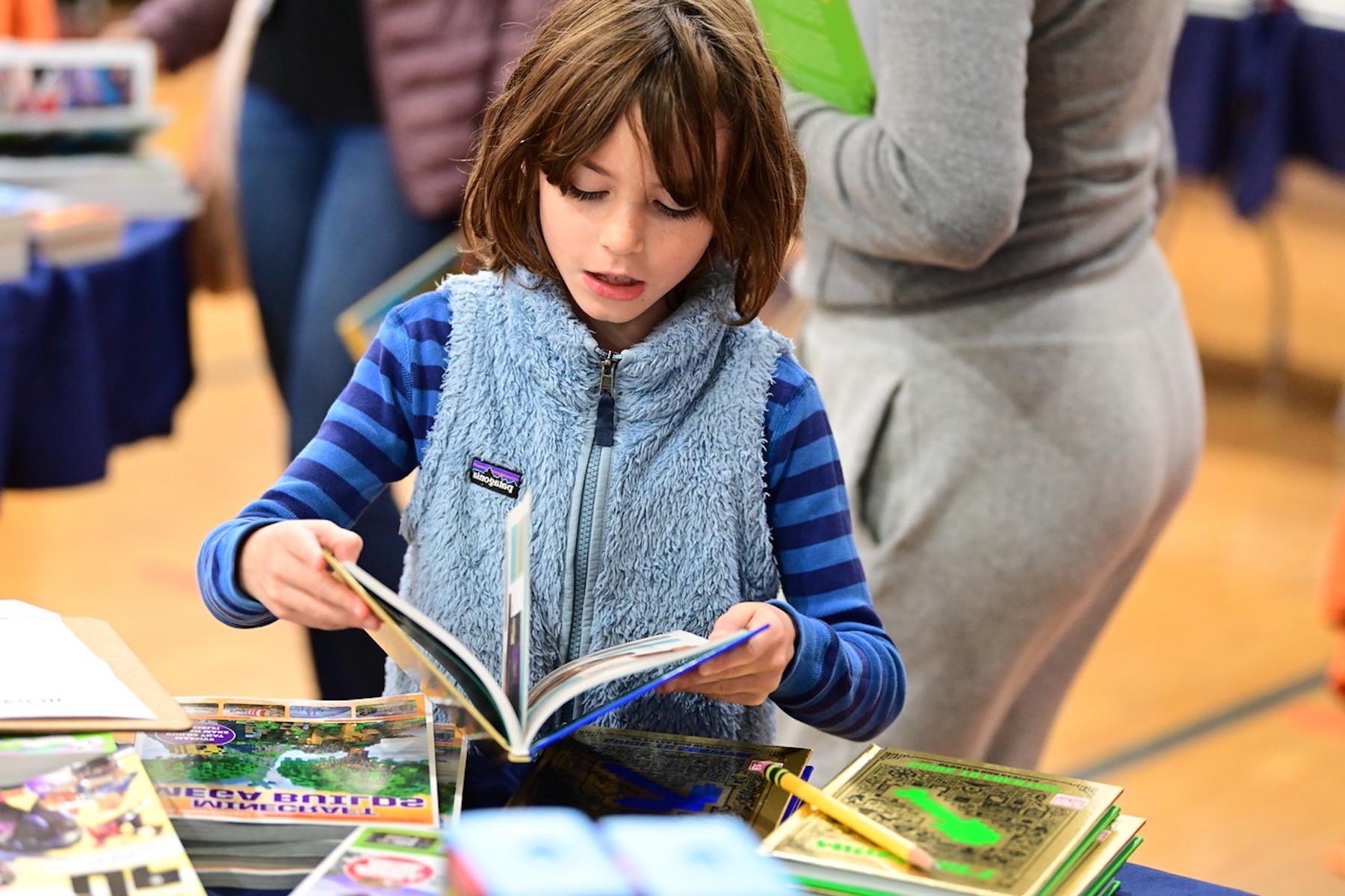 Student at Fieldston Lower browses for books at the ECFS Celebration of Books.