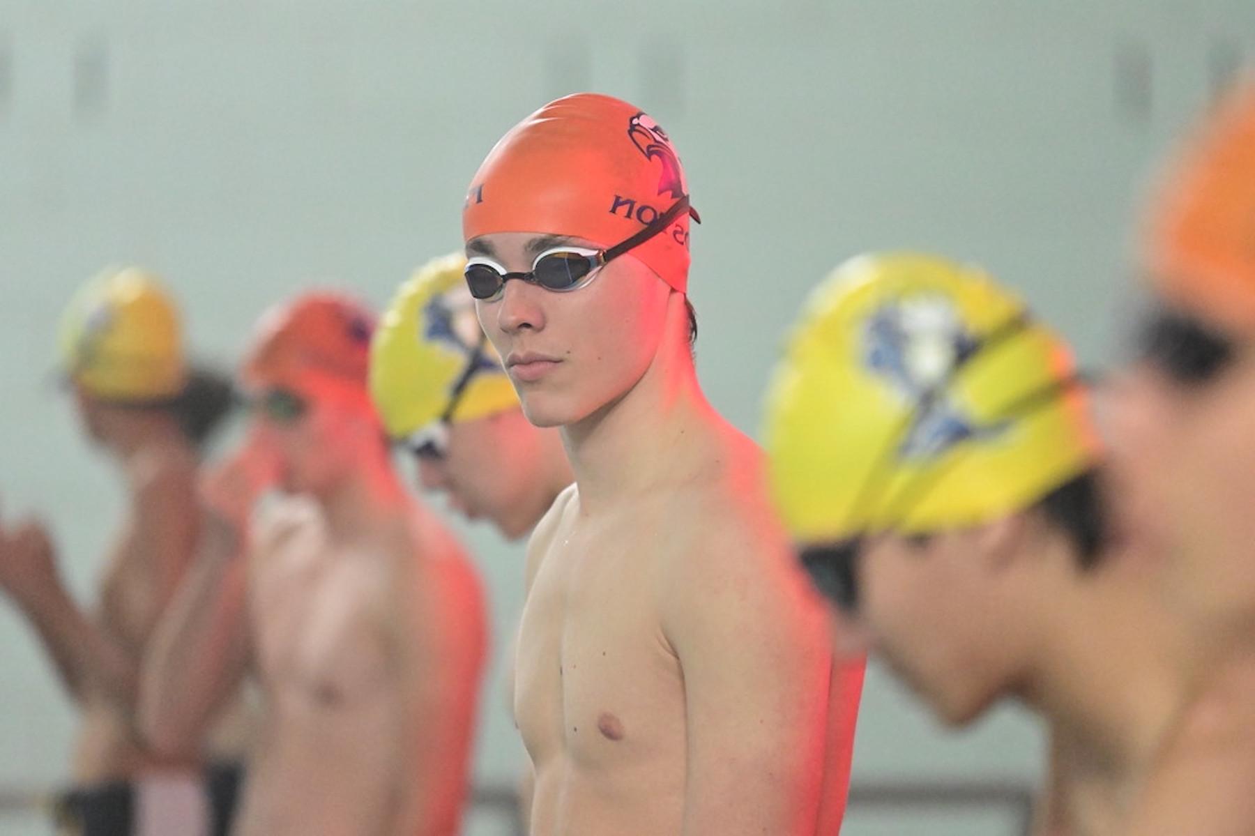 Fieldston Upper swimmer wearing swim cap and goggles looks to camera.