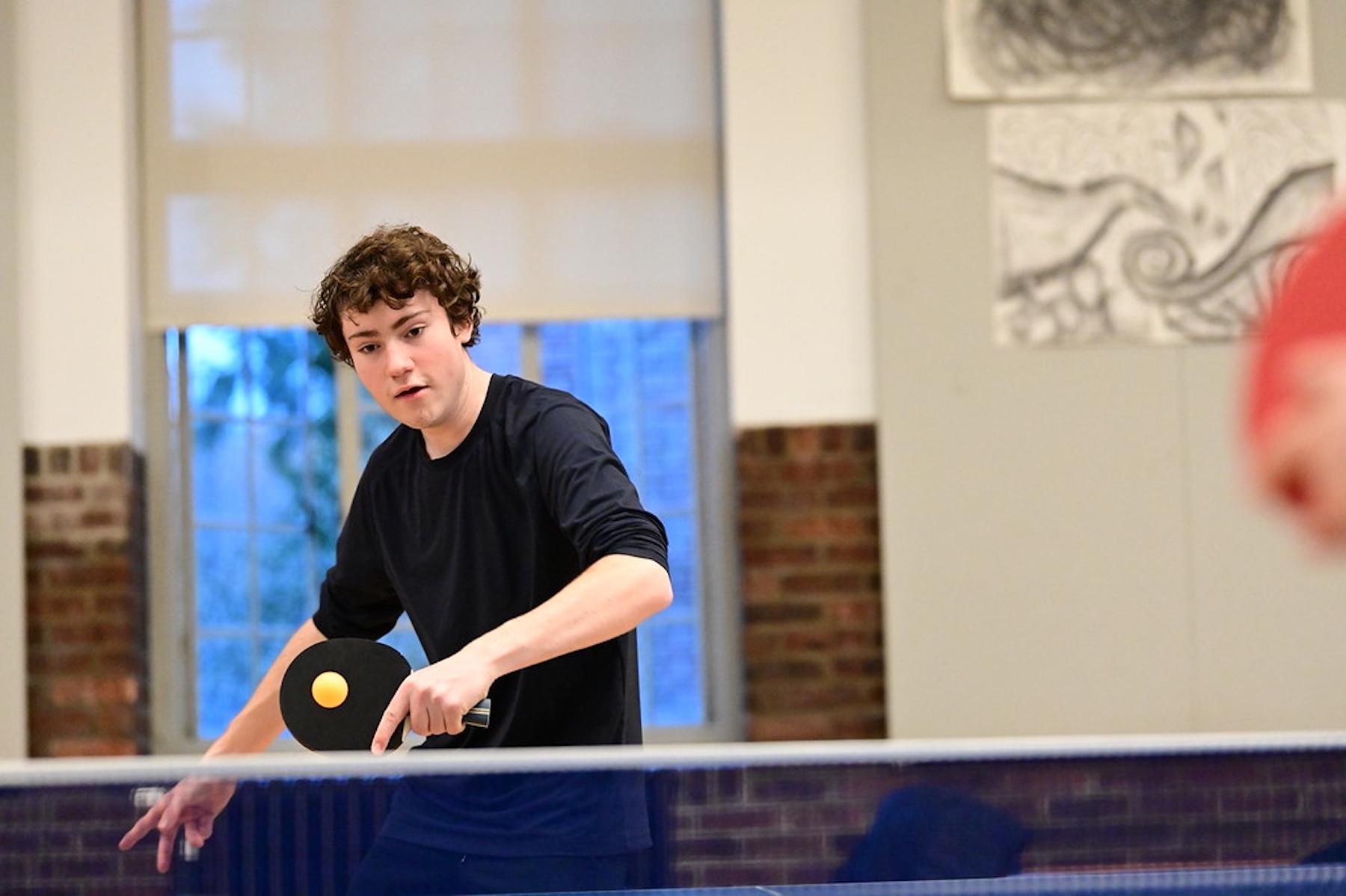 Fieldston Upper student practices table tennis in the Student Commons.