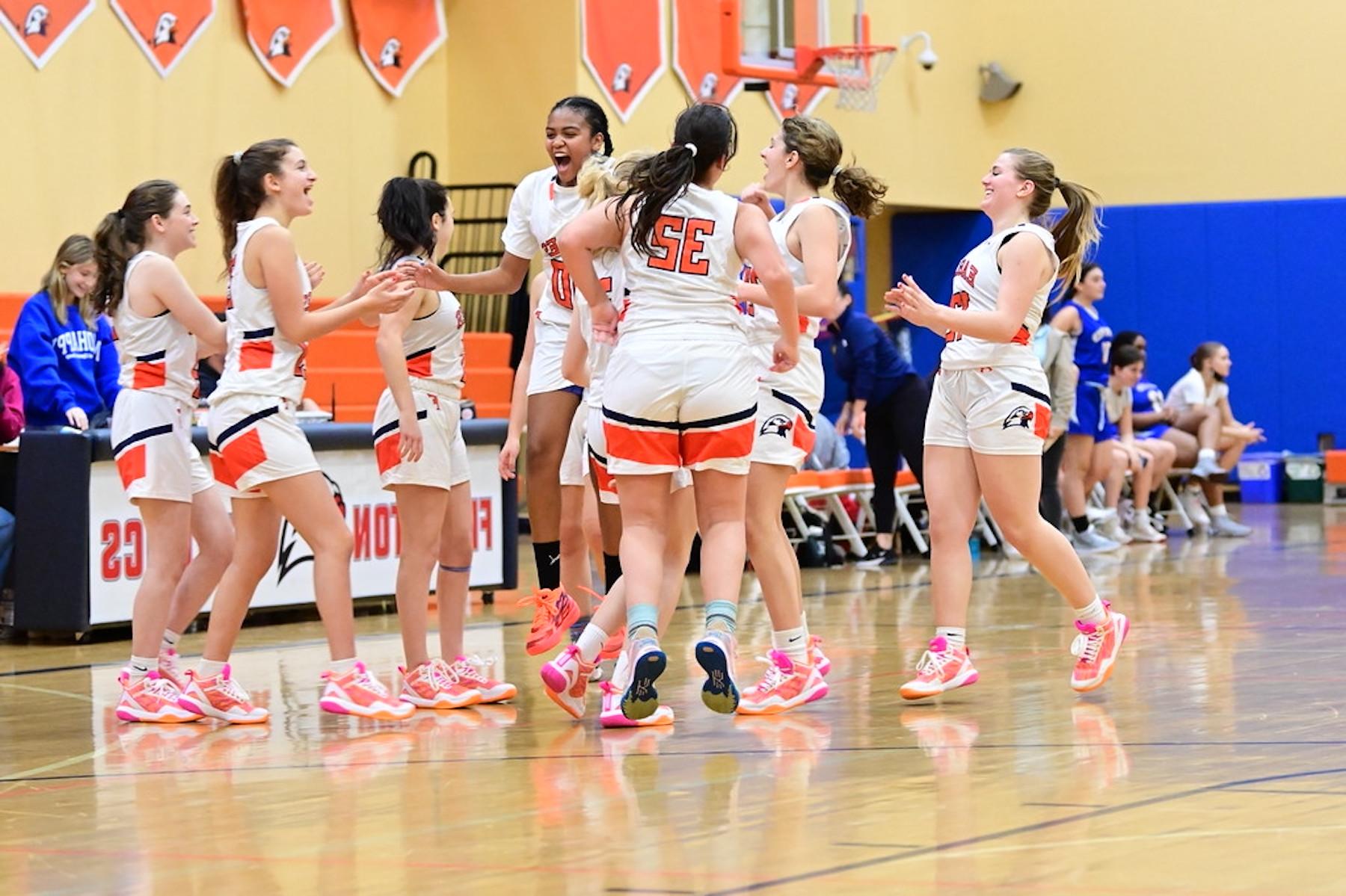 菲尔德斯顿·厄普的女子大学篮球队在大学体育馆进行比赛. 他们庆祝胜利!