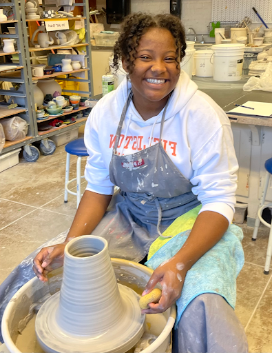 菲尔德斯顿高年级学生在艺术工作室做陶瓷项目时摆姿势和微笑.